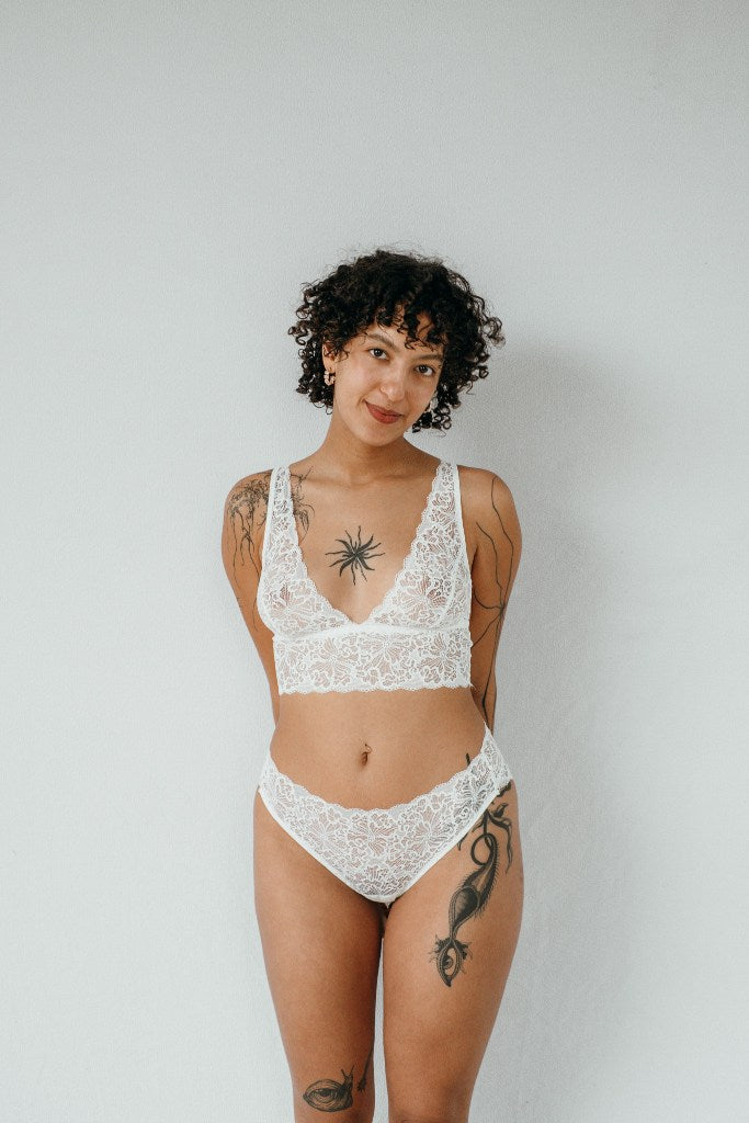 the woman in the photo is wearing white underwear consisting of a top and underpants in the color white