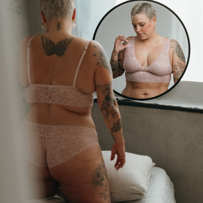the model with the short hair poses in front of the mirror in the beautiful Belle set