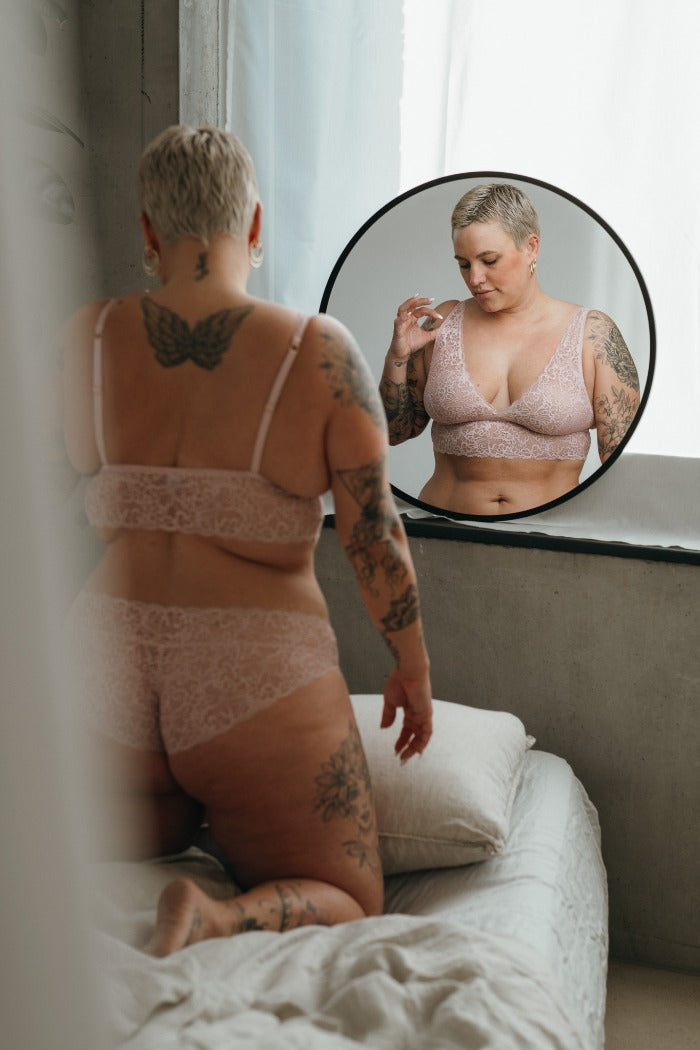the model with the short hair poses in front of the mirror in the beautiful Belle set