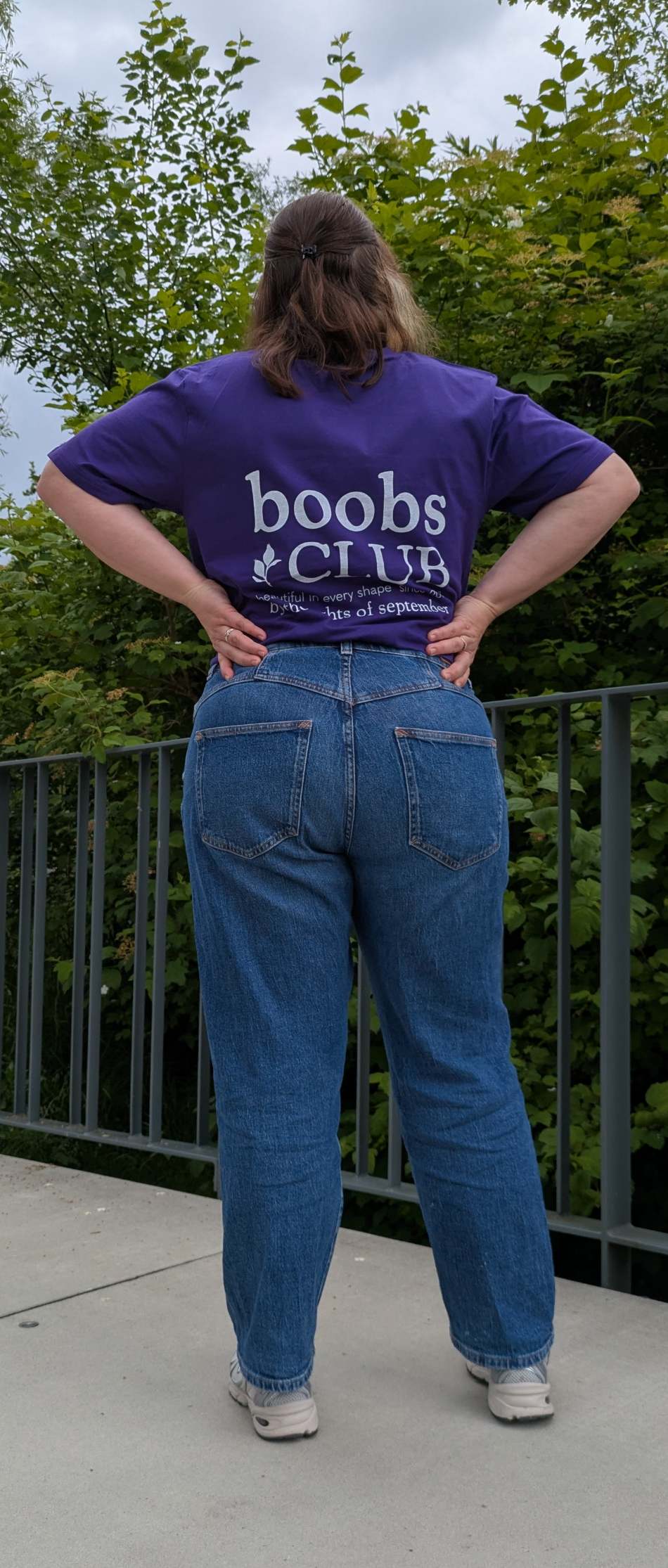 Foto zeigt Jess in unserem Boobs Club Shirt in violett von hinten mit dem Boobs Club Schriftzug.