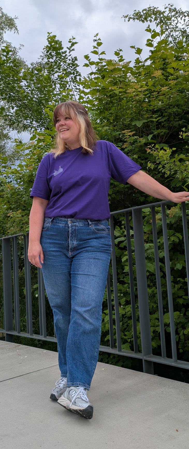 Foto zeigt Jess mit dem violetten Boobs Club Shirt von vorne. Sie lächelt seitwärts in die Kamera.