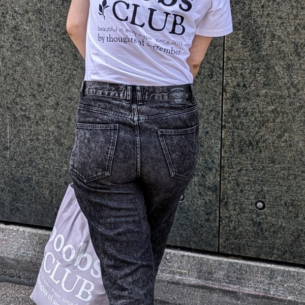 Foto zeigt Zippora in unserem Boobs Club Shirt in weiss von hinten mit dem Boobs Club Schriftzug.