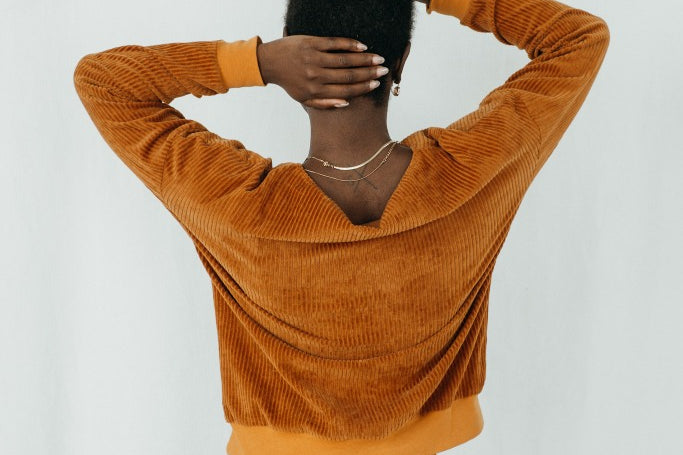 Model trägt Chloé Pullover in ockerfarbigem Cord, ihr Rücken ist der Kamera zugewandt