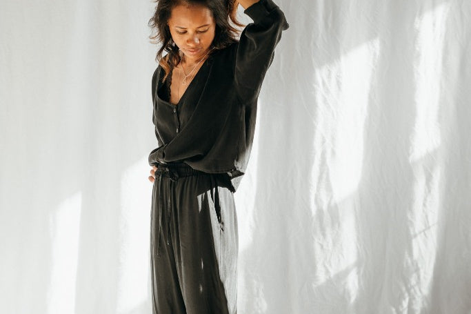La donna indossa pantaloni culottes dal taglio ampio e la blusa Coco in nero
