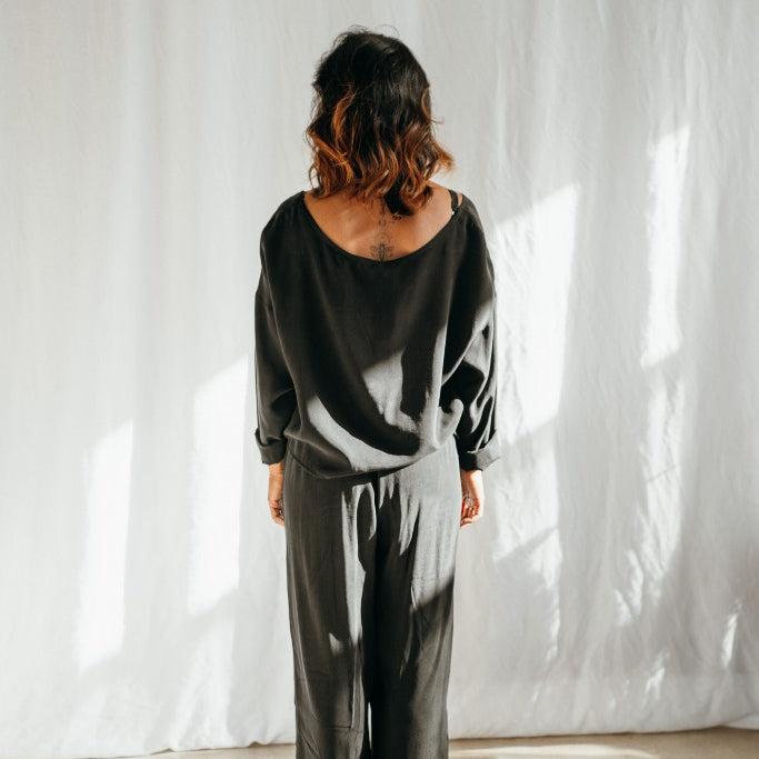 Woman in front of a white background wearing black pyjamas from thoughts of september.