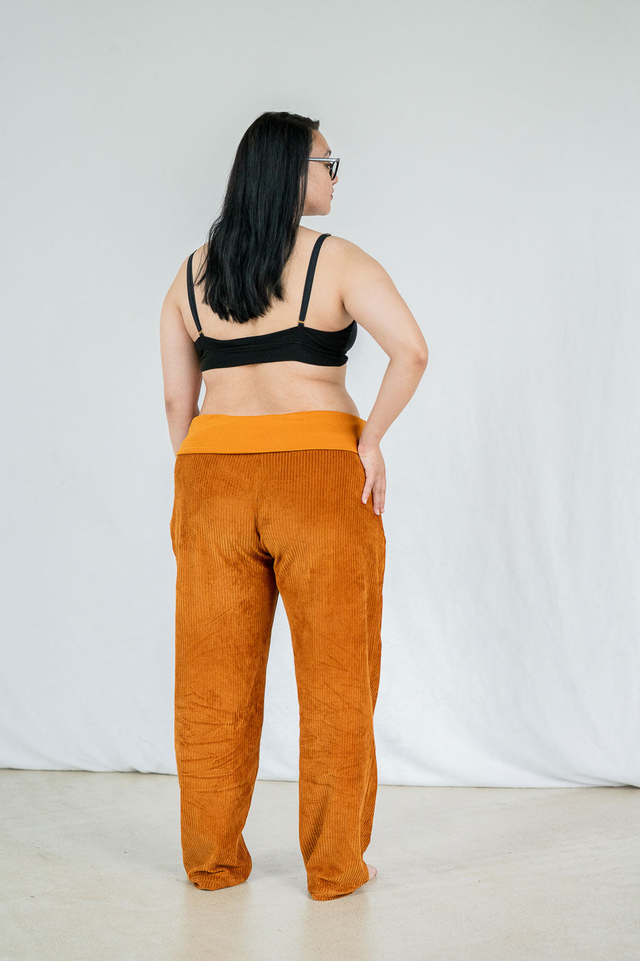 Model trägt Fiona Hose in ockerfarbigem Cord mit weichen Bündchen