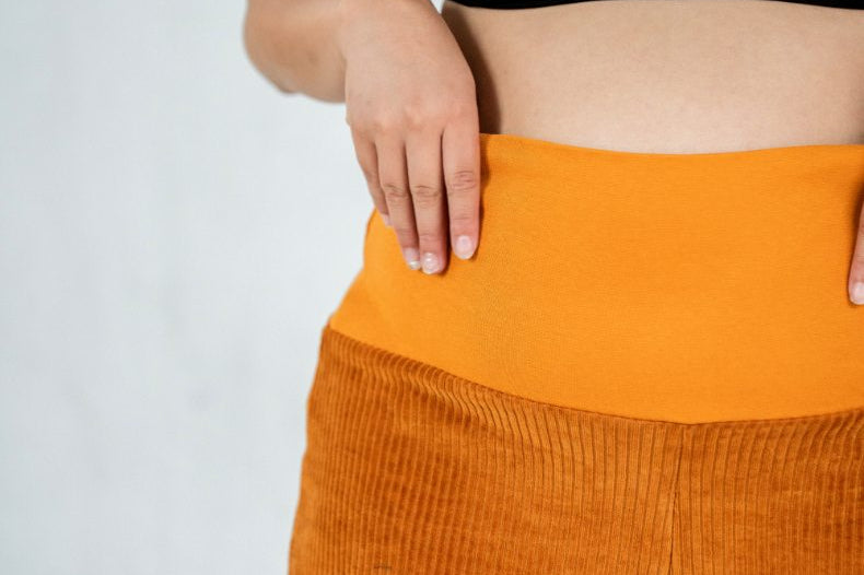 Detailaufnahme vom breiten Bündchen an der ockerfarbenen Fiona Cord-Hose