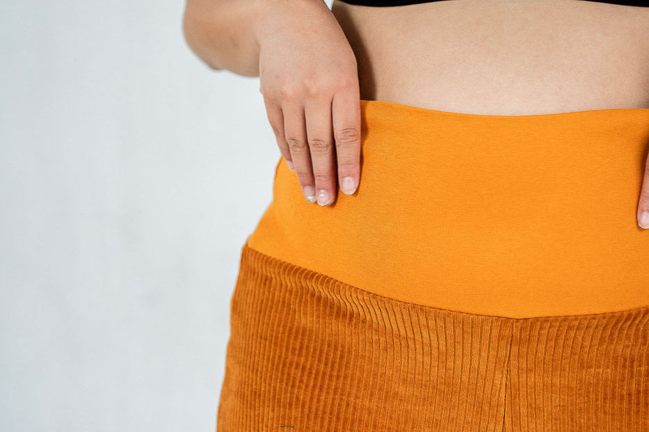 Detailaufnahme vom breiten Bündchen an der ockerfarbenen Fiona Cord-Hose