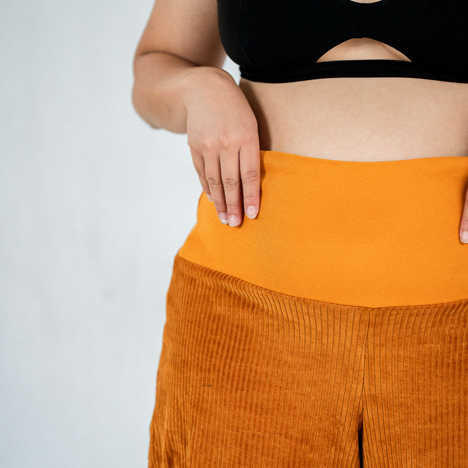 Detailaufnahme vom breiten Bündchen an der ockerfarbenen Fiona Cord-Hose