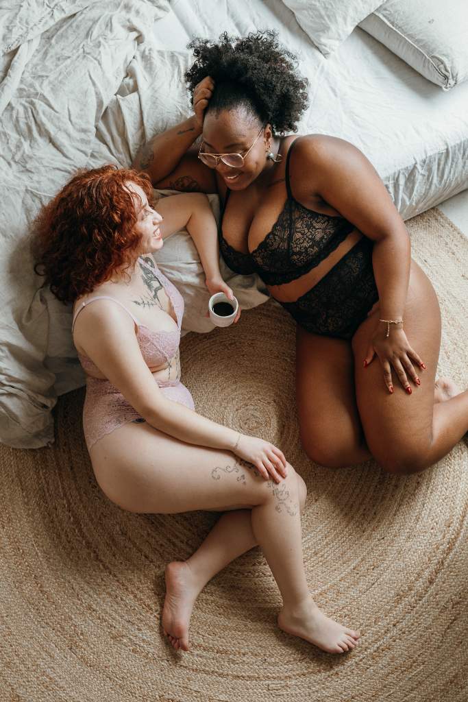 two women talking to each other and posing in beautiful lacy lingerie