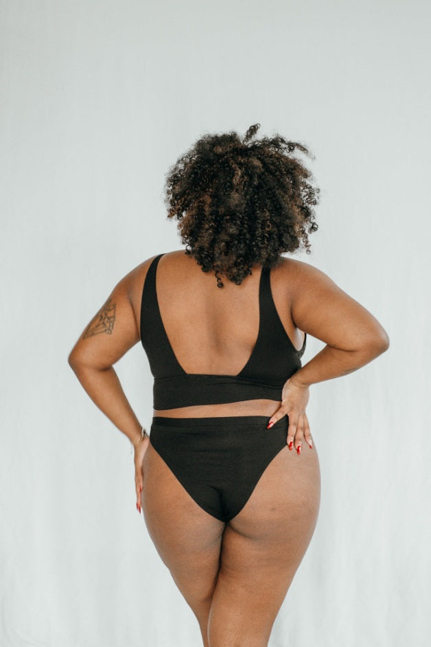 La modella si mostra da dietro e presenta il set di biancheria intima Leila in nero