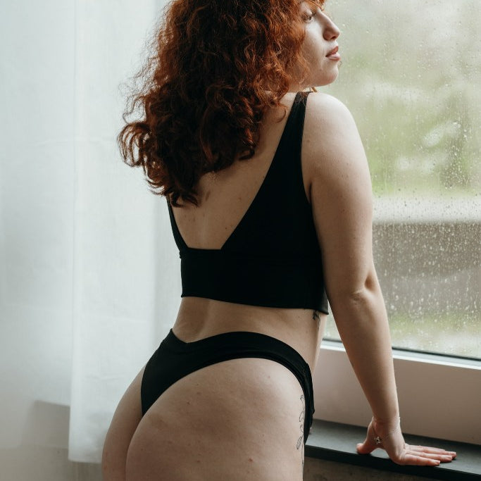 La donna si affaccia alla finestra e posa con il set nero di Leila.