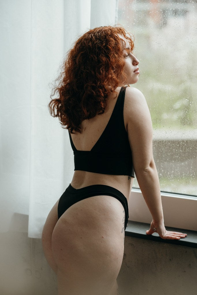 La donna si affaccia alla finestra e posa con il set nero di Leila.