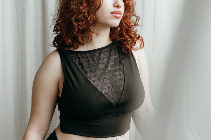 das Model mit den roten Locken trägt schöne Unterwäsche aus String und Bralette aus Lyocell Tencel