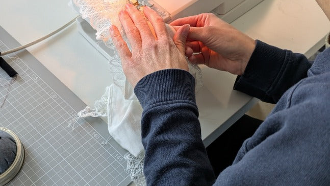 Foto zeigt eine unserer Workshopteilnehmerinnen von hinten an der Nähmaschine. Sie näht gerade an ihrem Slip.