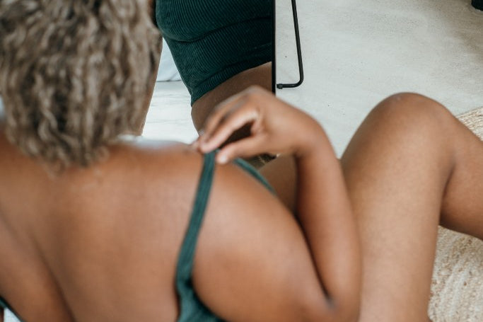 Detailaufnahme vom jadegrünen Ronja Body. Model sitzt vor dem Spiegel.