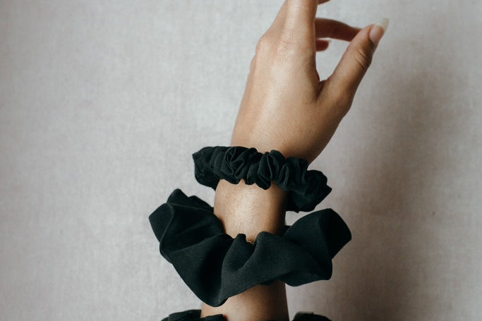 Drei unterschiedliche Scrunchies aus Restmaterialien an einem Handgelenk.