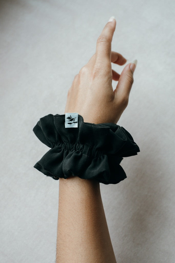 Large scrunchie made from leftover materials on an outstretched wrist.
