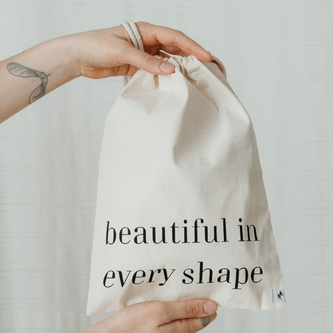 Hand holding wash bag with imprint "beautiful in every shape"