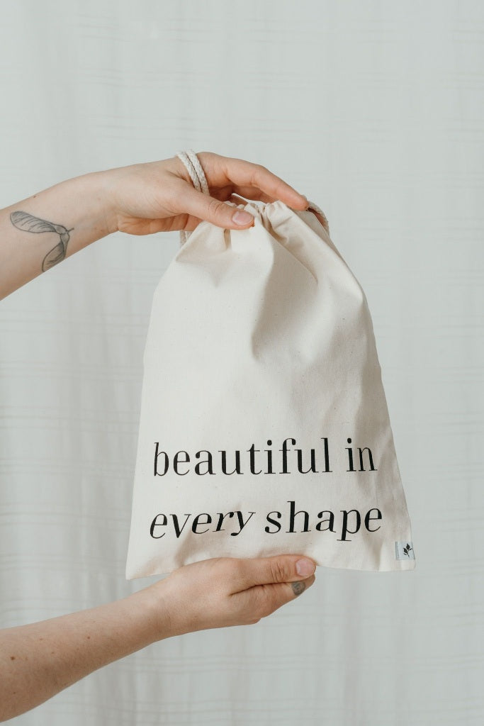 Hand holding wash bag with imprint "beautiful in every shape"