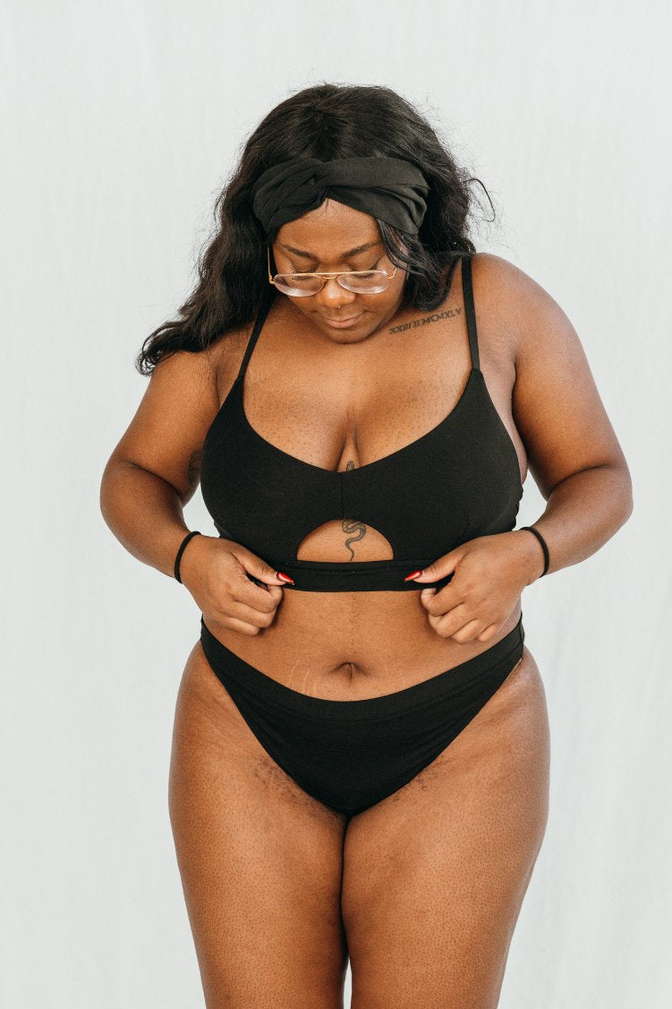 Plus size model wears bra with cut-out and plain underpants in black.