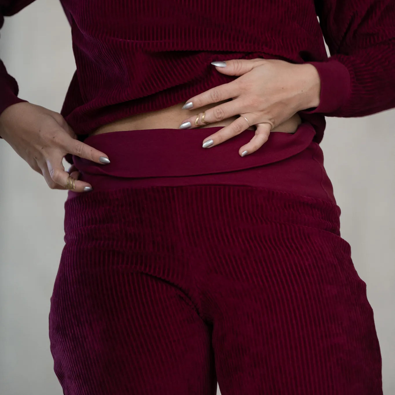 Detailaufnahme der Fiona Hose in Ruby Red. Das Model klappt den Saum um.