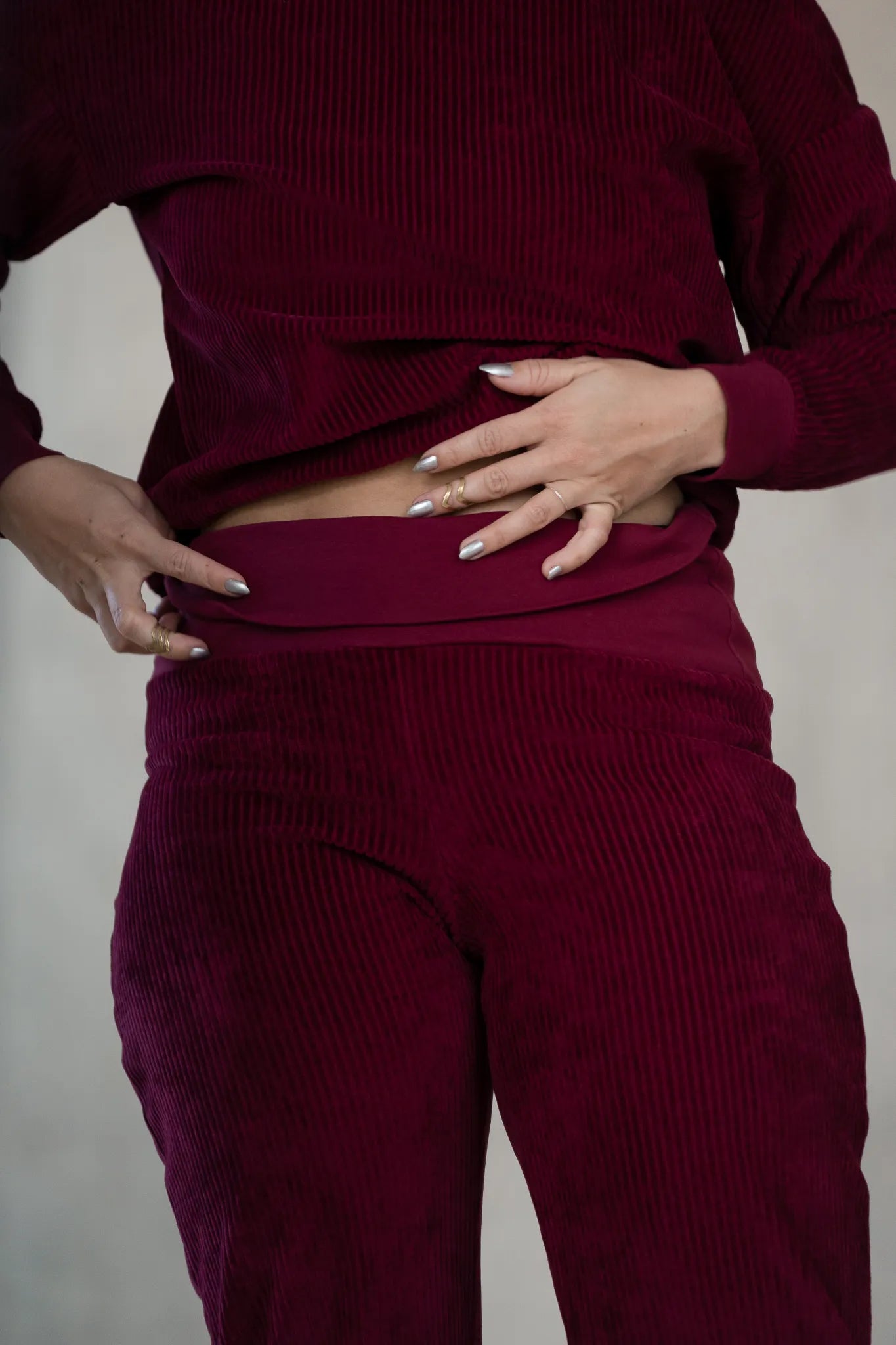 Detailaufnahme der Fiona Hose in Ruby Red. Das Model klappt den Saum um.