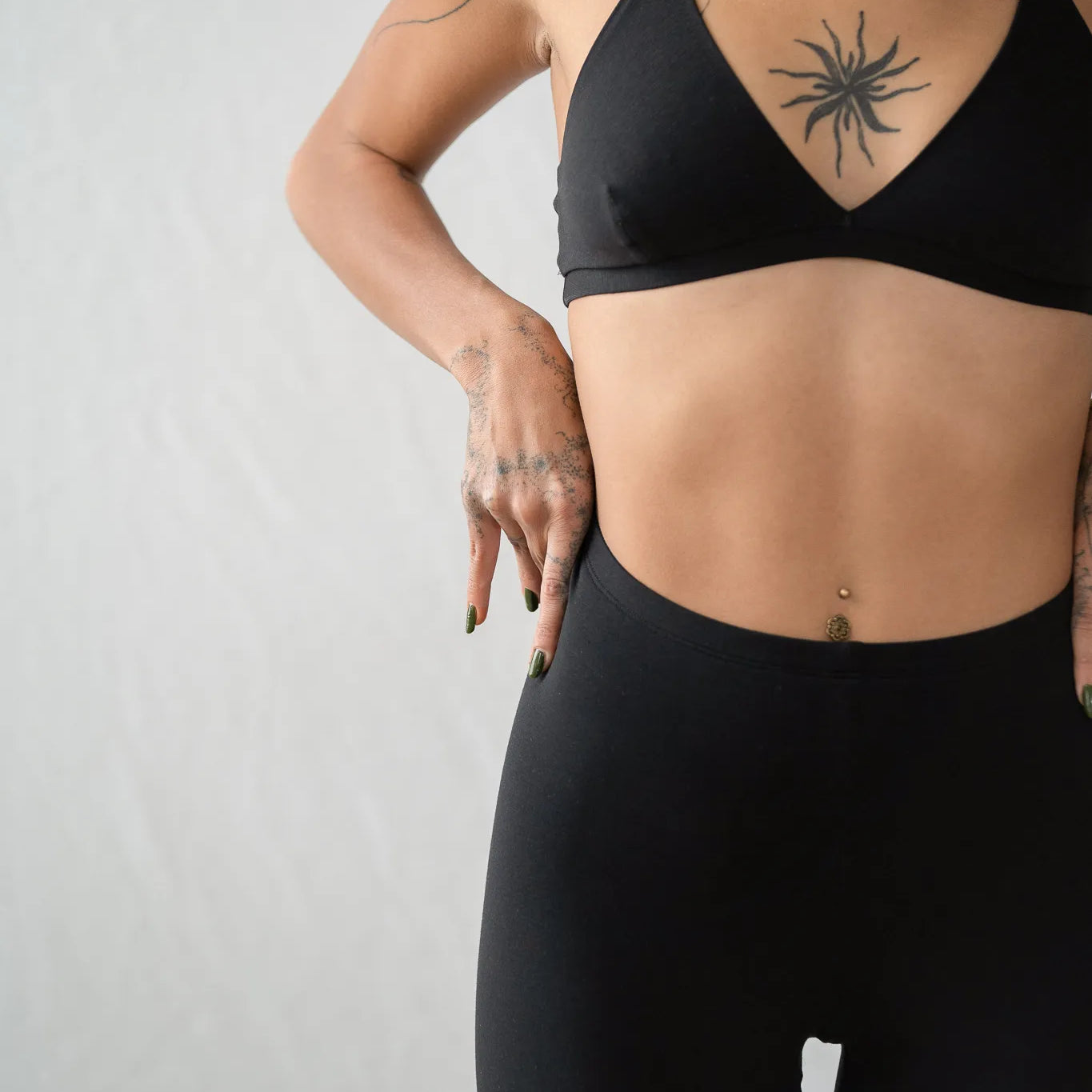 Detailaufnahme von der Inge Leggins. Das Model zieht sich die schwarze Leggins noch ein bisschen höher zum Bauchnabel hin.