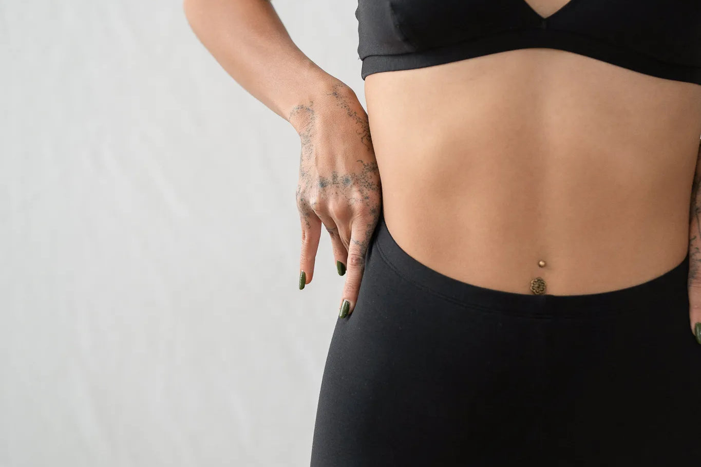 Detailaufnahme von der Inge Leggins. Das Model zieht sich die schwarze Leggins noch ein bisschen höher zum Bauchnabel hin.