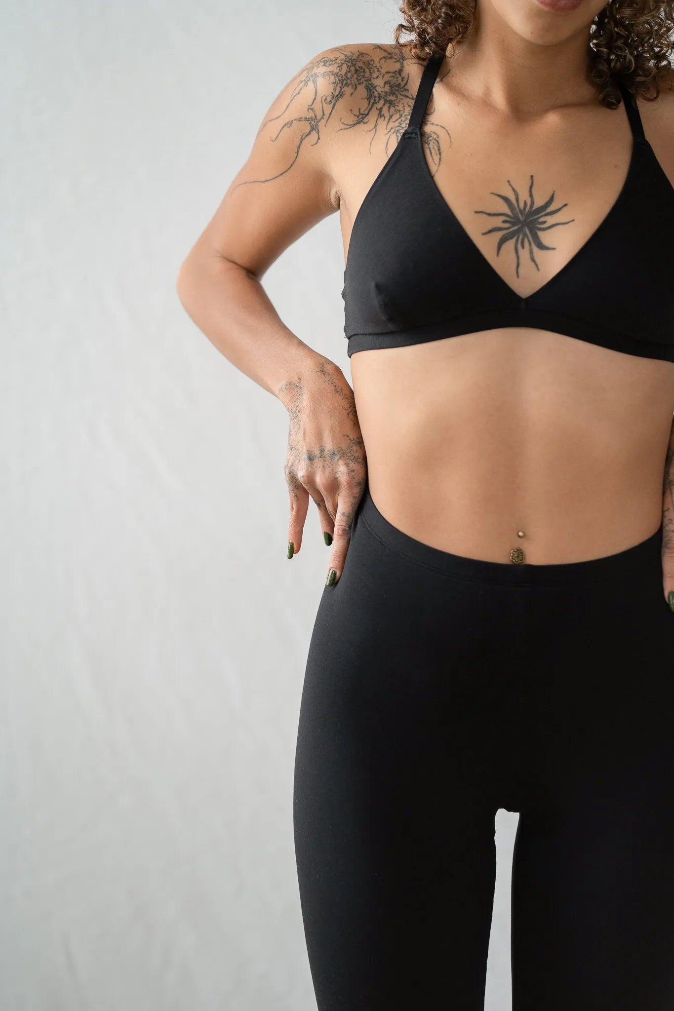 Detailaufnahme von der Inge Leggins. Das Model zieht sich die schwarze Leggins noch ein bisschen höher zum Bauchnabel hin.