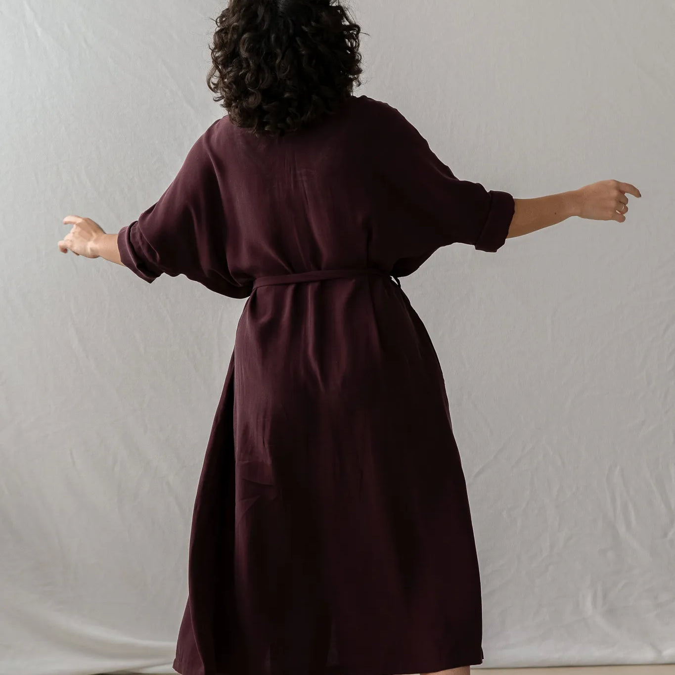 Frau tanzt in Kleid Kim in Aubergine - von thoughts of september