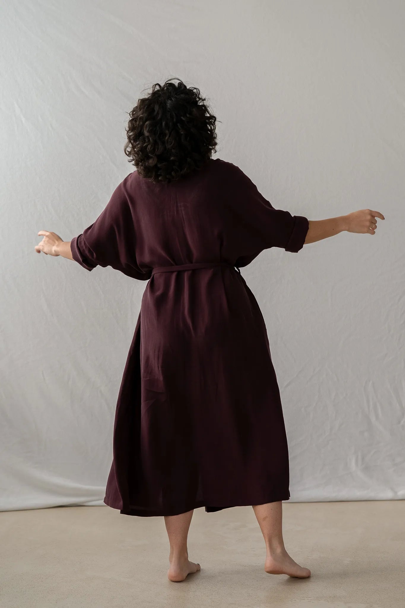 Frau tanzt in Kleid Kim in Aubergine - von thoughts of september