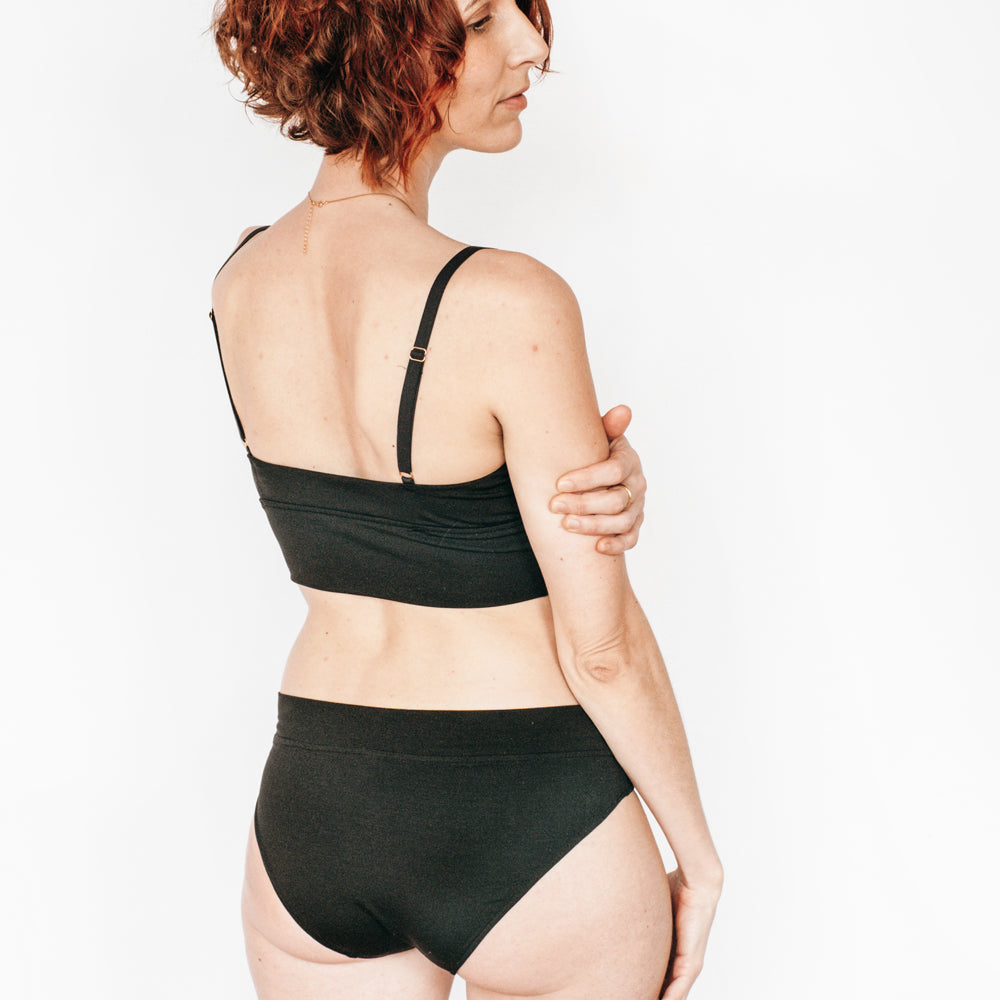 La persona indossa slip e Bralette realizzati in TENCEL™ sostenibile.