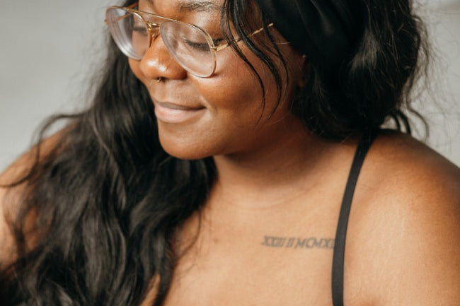 Woman wears black Bralette and has a hair band tied in her hair.