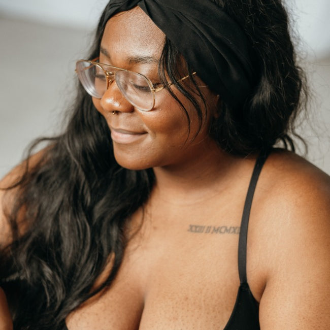 Woman wears black Bralette and has a hair band tied in her hair.