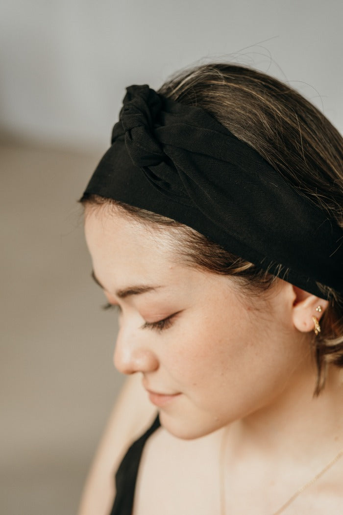 Donna con capelli lunghi legati all'indietro con un elastico nero.