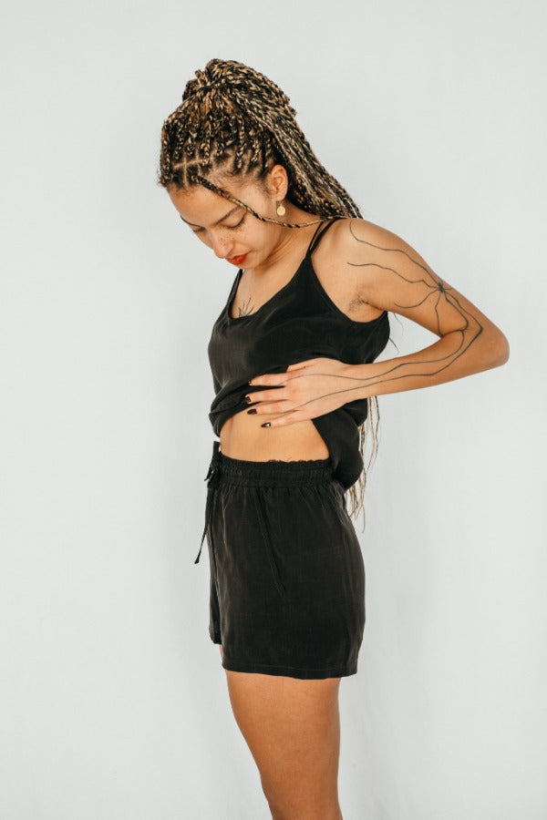 Model trägt Shorts mit Gummizug und Taschen, dazu ein schwarzes Top.