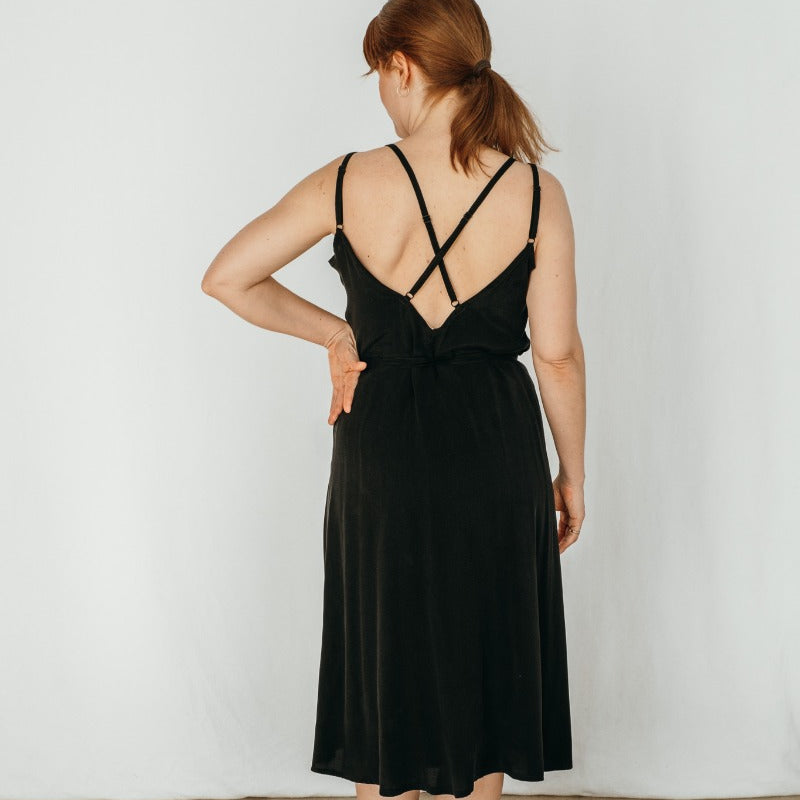 Woman wearing black summer dress with fine straps of thoughts of september