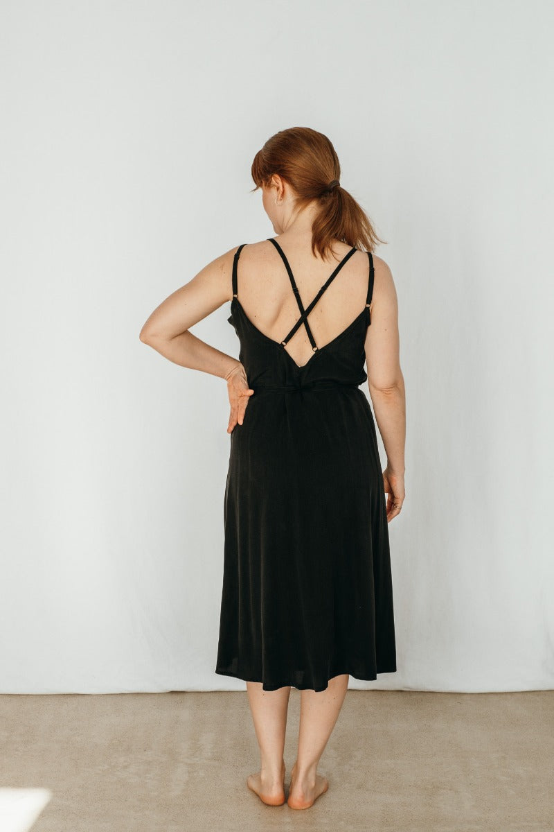 Woman wearing black summer dress with fine straps of thoughts of september
