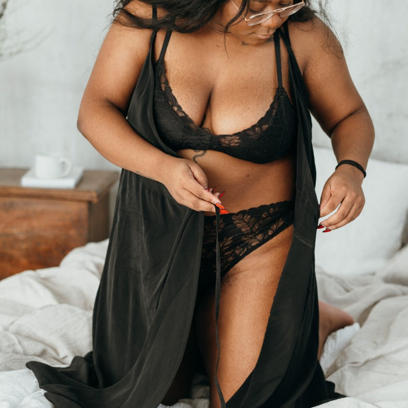 Woman tying up the black negligee made of cupro by thoughts of september